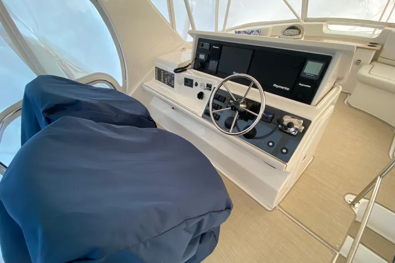 Slide: The Image of 2008 Silverton 45 Convertible yacht helm with covered seats and advanced navigation equipment. - 16