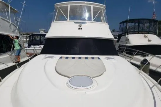 Slide: The Image of 2008 Silverton 45 Convertible yacht docked at a marina under clear blue skies. - 2