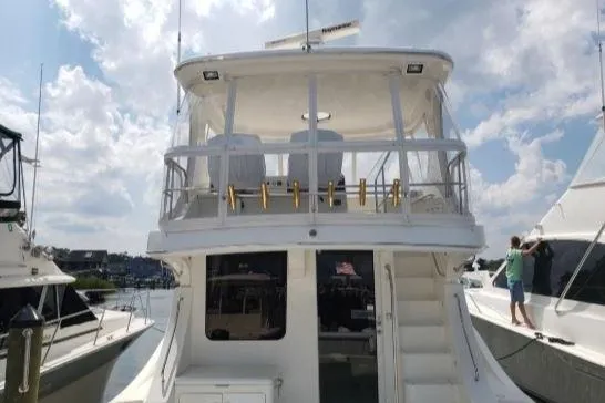 Slide: The Image of 2008 Silverton 45 Convertible yacht docked under a partly cloudy sky. - 5