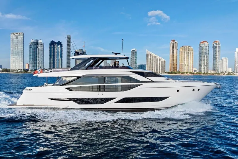 Slide: The Image of 2023 Ferretti Yachts 860 cruising near a city skyline on a sunny day. - 2