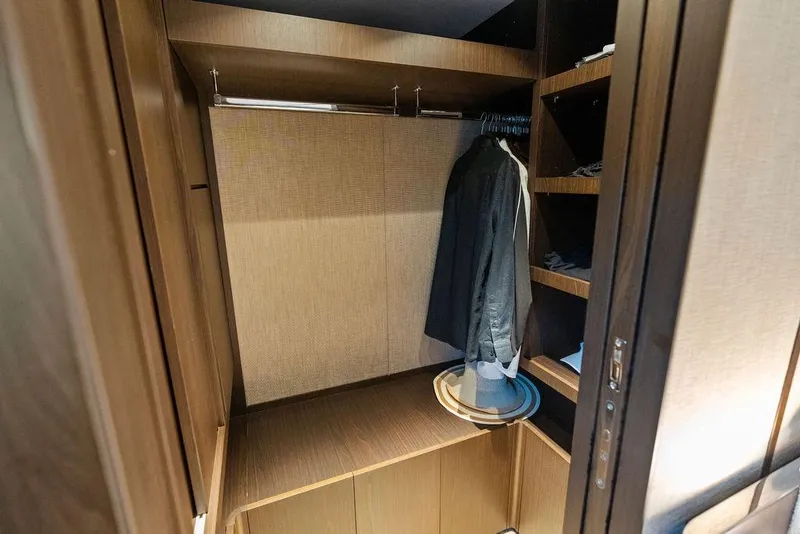 Slide: The Image of Luxurious wooden closet interior on 2023 Ferretti Yachts 860, featuring hanging space and shelves. - 48
