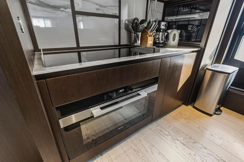 Slide: The Image of Modern kitchen interior on 2023 Ferretti Yachts 860, featuring sleek appliances and wooden cabinetry. - 17