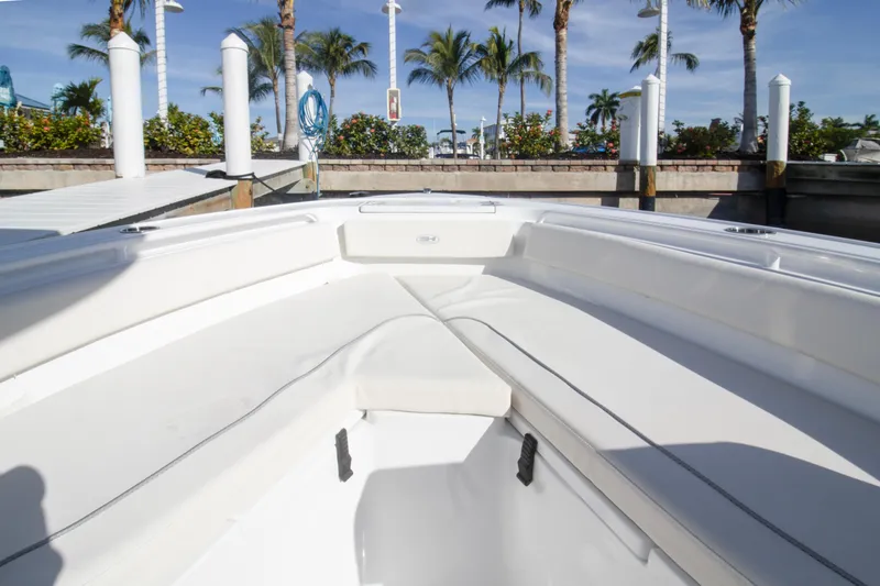 Slide: The Image of 2026 Sea Hunt Ultra 245 SE boat interior with white seating and dock view. - 13