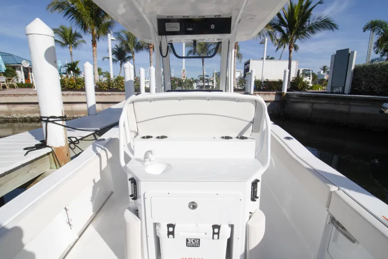 Slide: The Image of 2026 Sea Hunt Ultra 245 SE boat interior at dock with palm trees. - 6