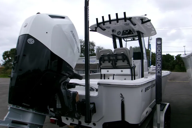Slide: The Image of 2024 Sportsman Masters 267OE Bay Boat with Mercury engine, docked outdoors. - 2