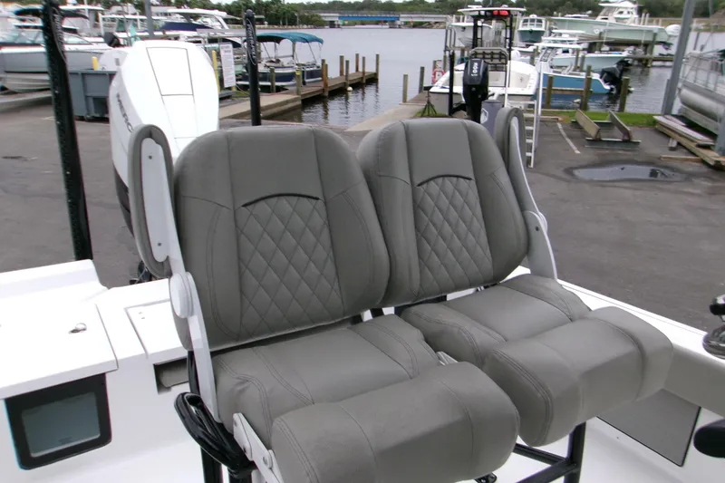 Slide: The Image of 2024 Sportsman Masters 267OE Bay Boat with dual gray cushioned seats at marina. - 5