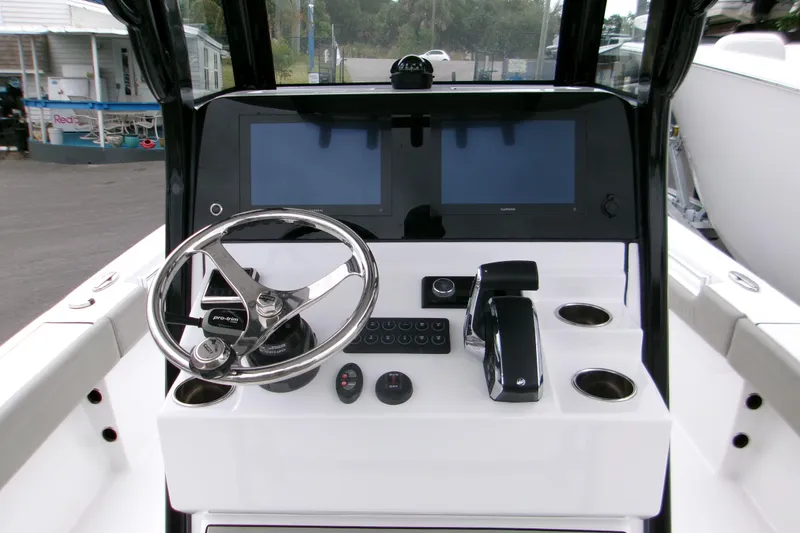 Slide: The Image of 2024 Sportsman Masters 267OE Bay Boat dashboard with steering wheel and dual screens. - 9