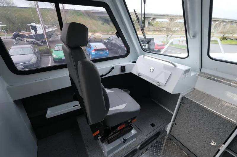 Slide: The Image of Interior of 2025 Hewescraft 250 Alaskan boat, featuring a captain's chair and control panel. - 11