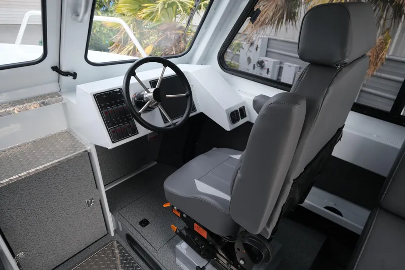 Slide: The Image of 2025 Hewescraft 250 Alaskan boat interior with steering wheel and captain's seat. - 13