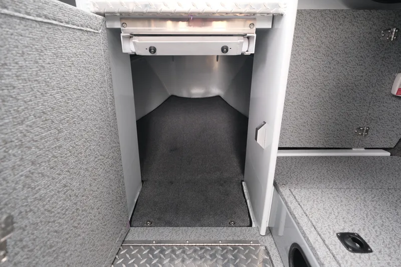 Slide: The Image of 2025 Hewescraft 250 Alaskan interior storage compartment with carpeted flooring and metal accents. - 16