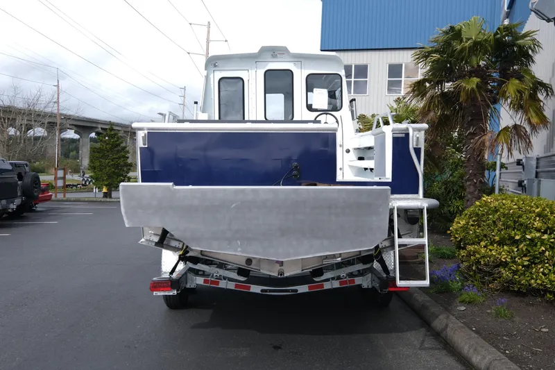 Slide: The Image of 2025 Hewescraft 250 Alaskan boat, rear view, parked outdoors near palm trees. - 5
