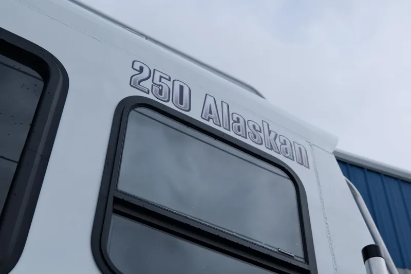 Slide: The Image of 2025 Hewescraft 250 Alaskan boat exterior with windows and model name. - 6