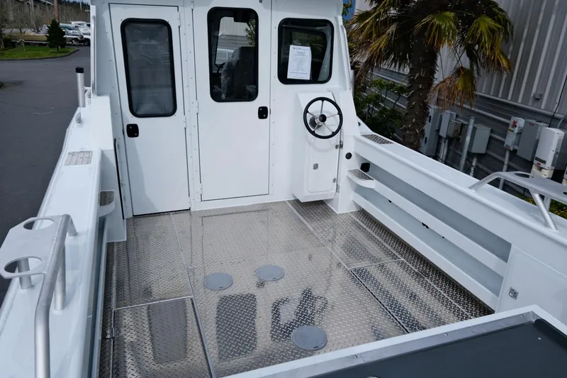 Slide: The Image of 2025 Hewescraft 250 Alaskan boat interior with steering wheel and metal flooring. - 7