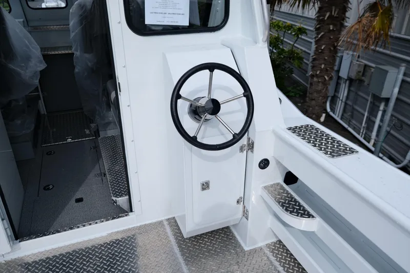 Slide: The Image of 2025 Hewescraft 250 Alaskan boat interior with steering wheel and metal flooring. - 9