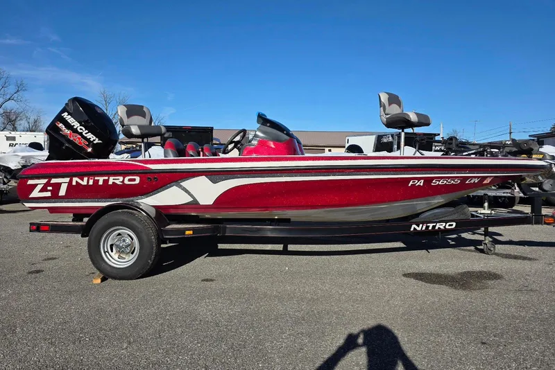 The Image of 2014 Nitro Z-7 boat with Mercury engine, red and white design, parked on trailer. - 1