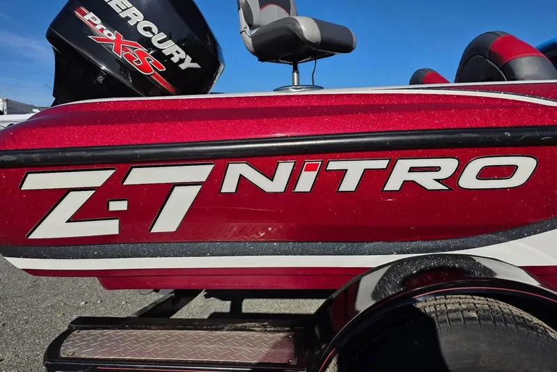 Slide: The Image of Red 2014 Nitro Z-7 boat with Mercury Pro XS engine, parked on gravel. - 4