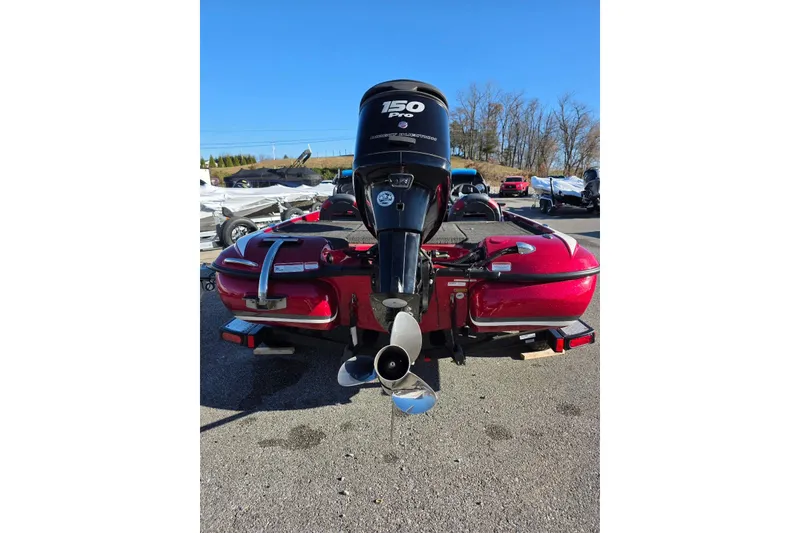 Slide: The Image of Red 2014 Nitro Z-7 boat with 150 HP engine, parked outdoors. - 7