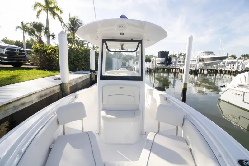 Slide: The Image of 2026 Sea Hunt Ultra 245 SE boat docked at a marina with palm trees. - 12