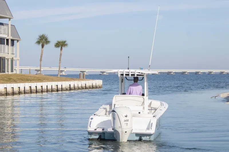 Slide: The Image of 2026 Sea Hunt Ultra 245 SE boat navigating a serene coastal waterway. - 3