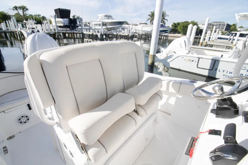 Slide: The Image of 2026 Sea Hunt Ultra 245 SE boat interior with plush seating at marina. - 8