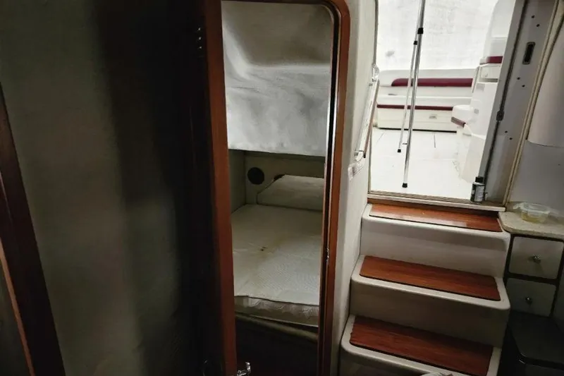 Slide: The Image of 1992 Regal Commodore 400 boat interior with white seating and table under cover. - 18