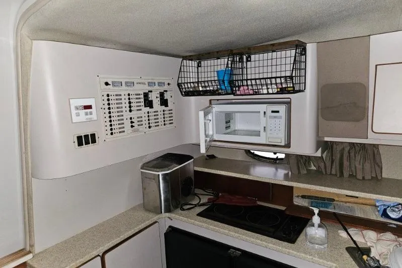 Slide: The Image of 1992 Regal Commodore 400 boat kitchen with microwave, control panel, and appliances. - 24