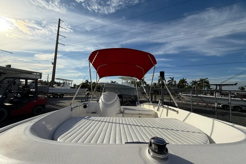Slide: The Image of 2017 Boston Whaler 150 Super Sport with red canopy, parked outdoors under blue sky. - 2