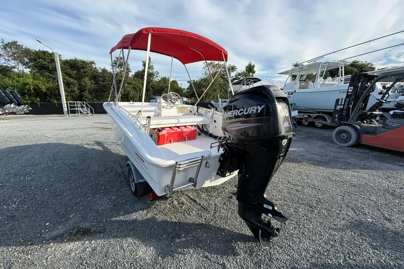 Slide: The Image of 2017 Boston Whaler 150 Super Sport boat with red canopy and Mercury outboard motor. - 3