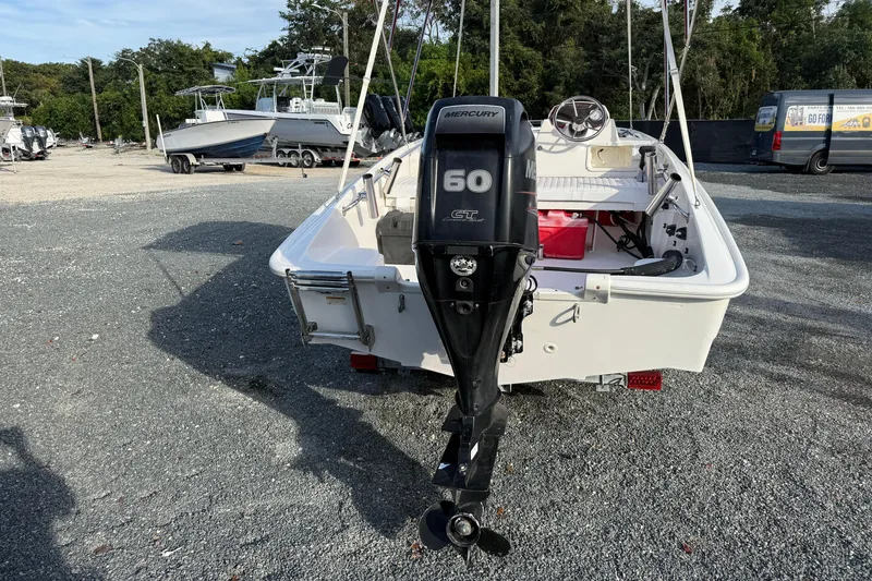 Slide: The Image of 2017 Boston Whaler 150 Super Sport with Mercury 60 outboard motor in a boatyard. - 4