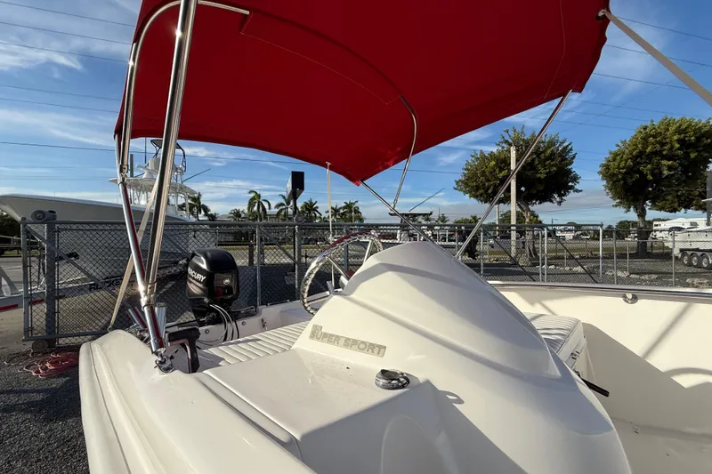 Slide: The Image of 2017 Boston Whaler 150 Super Sport with red canopy and Mercury engine. - 6