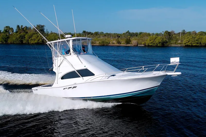 The Image of 1998 Luhrs 36 Convertible yacht cruising on a scenic river. - 0