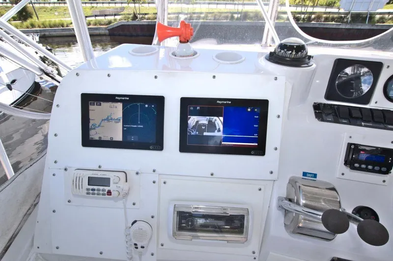 Slide: The Image of 1998 Luhrs 36 Convertible boat interior with white seating and helm station. - 24