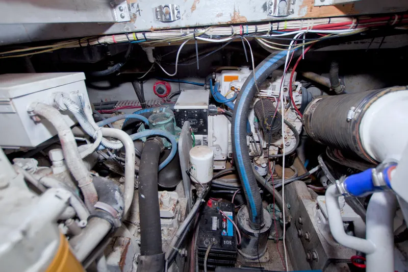 Slide: The Image of Engine room of a 1998 Luhrs 36 Convertible boat, showcasing mechanical components and wiring. - 64
