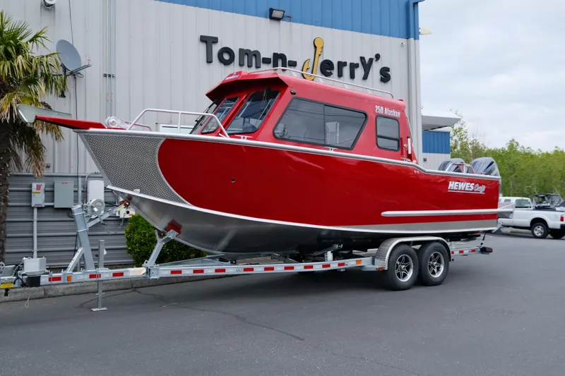 The Image of 2025 Hewescraft 250 Alaskan boat in red on a trailer outside a dealership. - 1