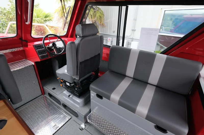 Slide: The Image of 2025 Hewescraft 250 Alaskan interior with gray seating and red accents. - 13