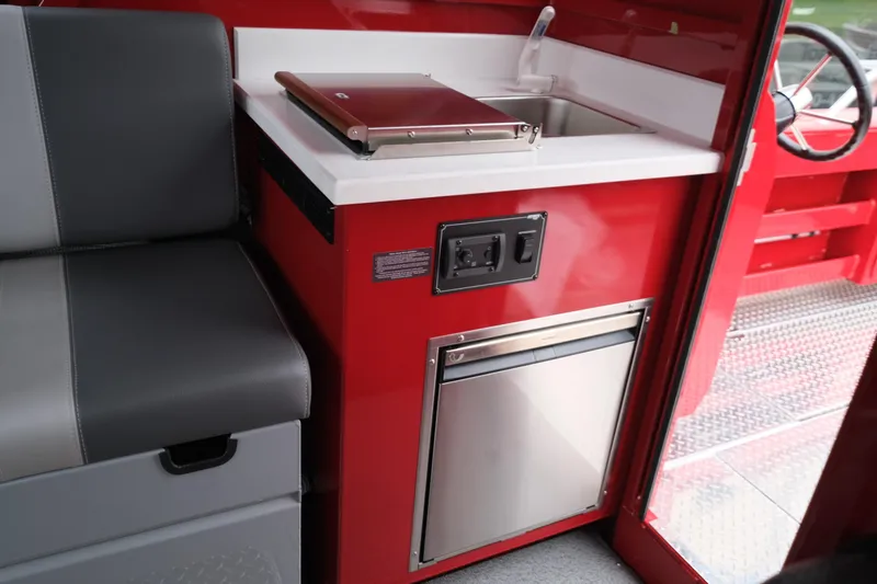 Slide: The Image of Interior of 2025 Hewescraft 250 Alaskan boat with red kitchenette and seating. - 19