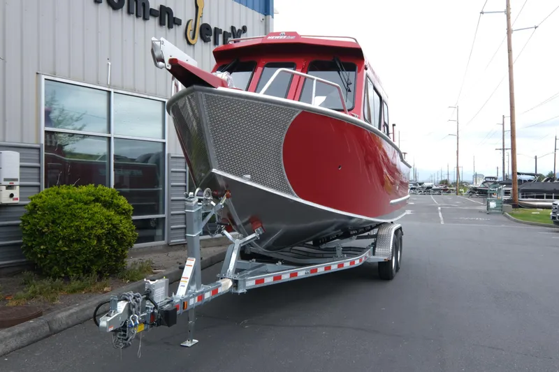 Slide: The Image of 2025 Hewescraft 250 Alaskan boat in red on a trailer, parked outside a building. - 3