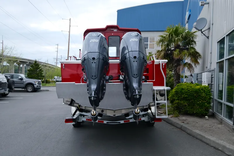 Slide: The Image of 2025 Hewescraft 250 Alaskan boat with dual 200 horsepower engines, parked outdoors. - 6