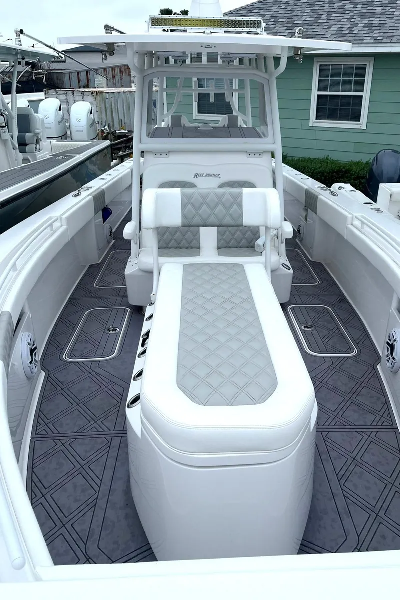 Slide: The Image of 2024 Reef Runner 340 boat with cushioned seating and modern design. - 10