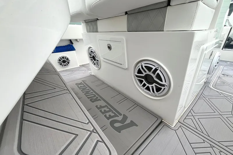 Slide: The Image of 2024 Reef Runner 340 boat interior with speakers and storage compartments. - 5