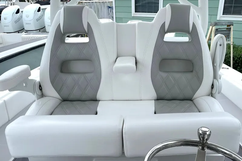 Slide: The Image of 2024 Reef Runner 340 boat with dual cushioned seats and steering wheel. - 7