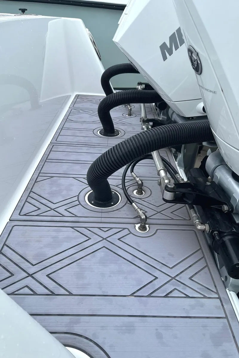 Slide: The Image of 2024 Reef Runner 340 boat deck with engine hoses and patterned flooring. - 9