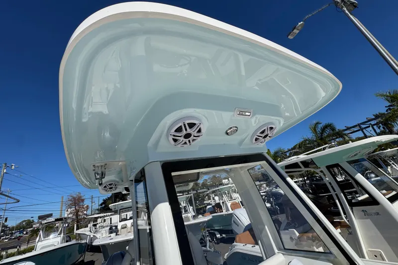 Slide: The Image of 2026 Key West 244 Center Console boat with speakers and canopy, under clear blue sky. - 30