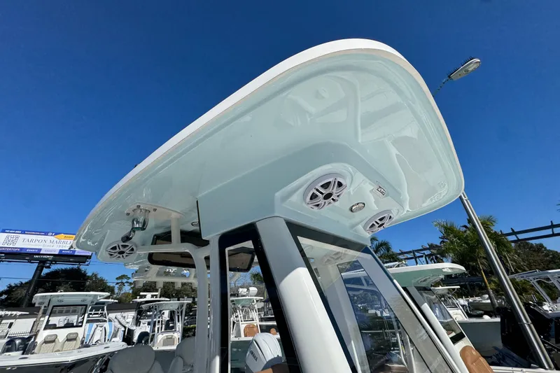 Slide: The Image of 2026 Key West 244 Center Console boat with speakers and canopy under clear blue sky. - 31