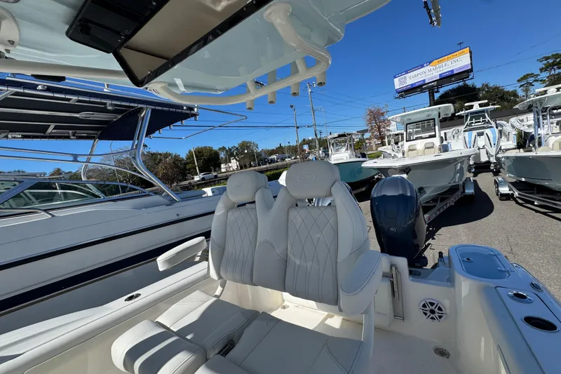 Slide: The Image of 2026 Key West 244 Center Console boat interior with seating and motor, displayed outdoors. - 36