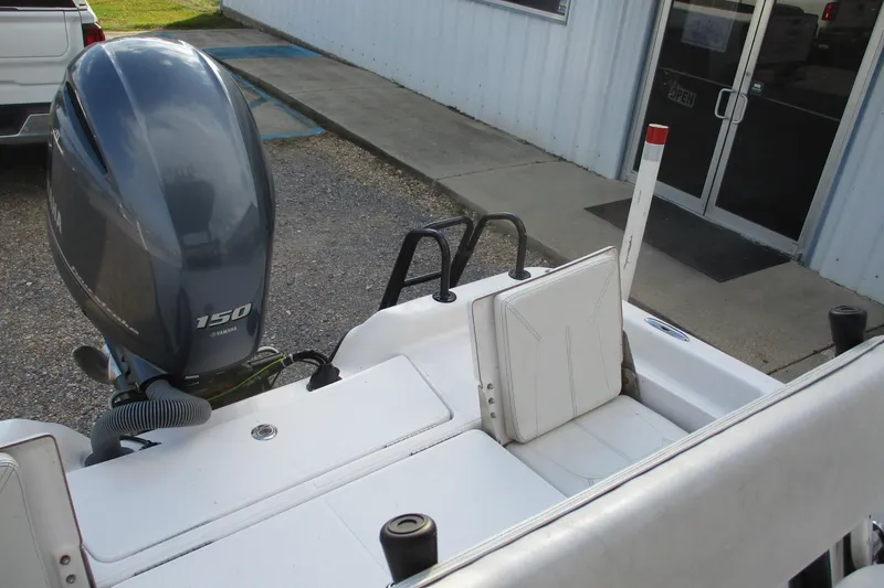 Slide: The Image of 2019 Blue Wave 2200 SL BAY boat with Yamaha 150 engine, parked near a building. - 16