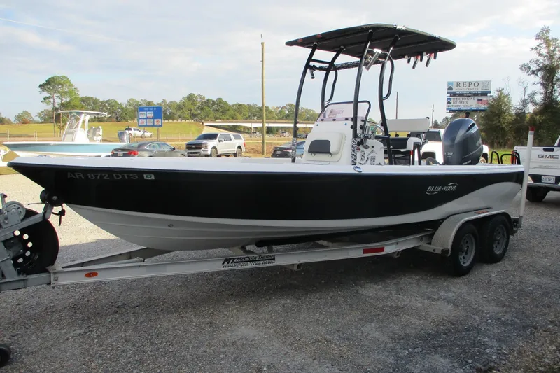 Slide: The Image of 2019 Blue Wave 2200 SL BAY boat on trailer, parked outdoors. - 2