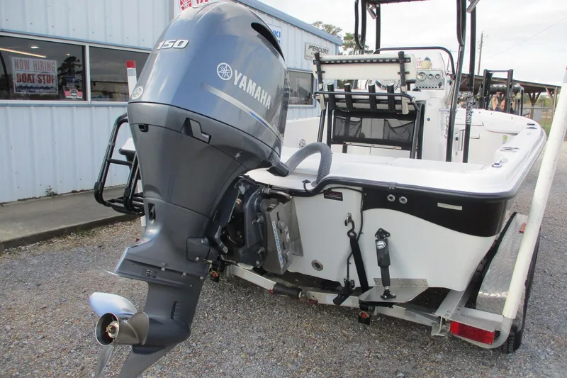 Slide: The Image of 2019 Blue Wave 2200 SL BAY boat with Yamaha 150 outboard motor, parked outside dealership. - 5