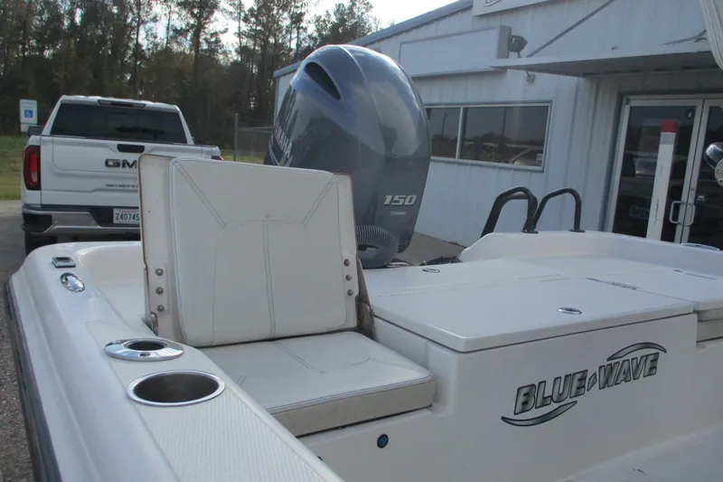 Slide: The Image of 2019 Blue Wave 2200 SL BAY boat with Yamaha 150 engine, parked near a GMC truck. - 6