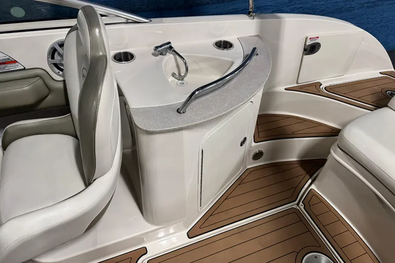 Slide: The Image of 2007 Sea Ray 260 Sundeck interior with seating and sink, featuring wood-style flooring. - 11